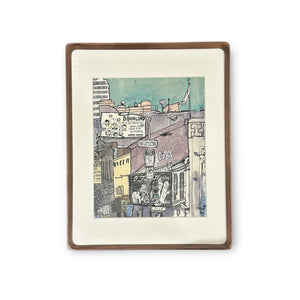 Framed original watercolor and graphite illustration of the corner of Polk Street and O'Farrell in San Francisco. Featuring a blue sky and view of the O'Farrell Theaters red building with yellow and white architecture in the background.