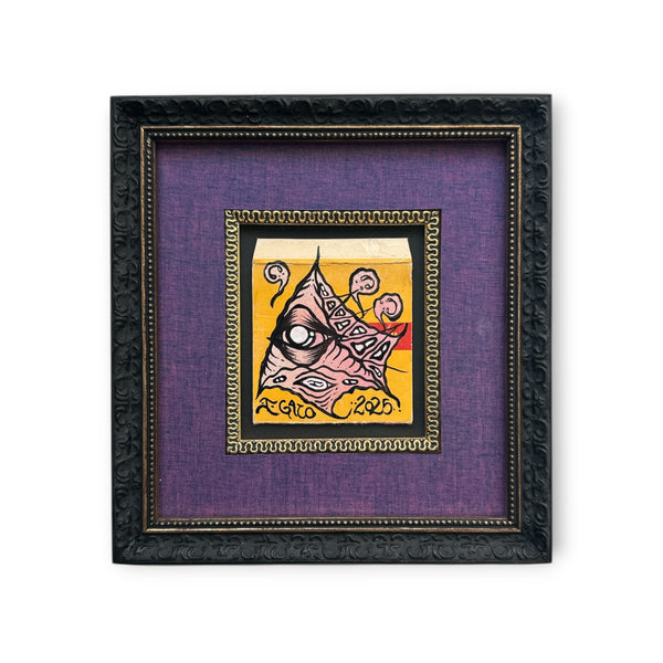 Original black framed mixed media Eye Gato artwork painted on vintage film packaging, featuring the pyramid eye design in peach, black, and yellow tones.