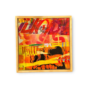 Mixed media of black skull collaged in a multitude of colors including red, yellow and orange tones painted on a wood board in a custom floating frame.